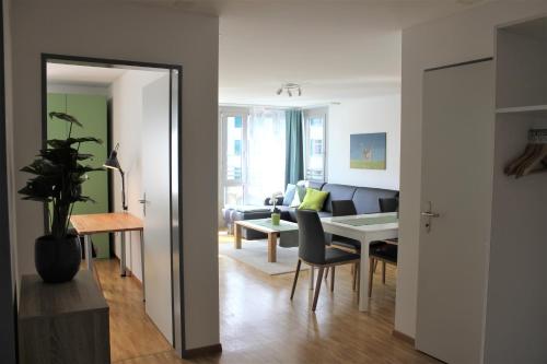 a living room with a table and a dining room at Herisau Apartments in Herisau