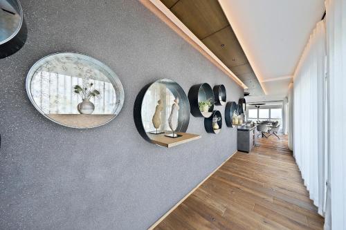 a hallway with round mirrors and vases on a wall at Appartement-Hotel Beatenhof in Tirolo