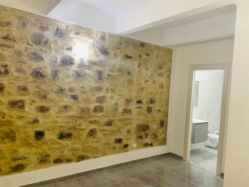 a bathroom with a stone wall in a room at Casa castello in Rocca Imperiale