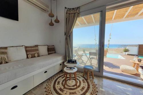 a living room with a couch and a large window at Tramonto Luxury Villa No1- Breathtaking sunset view in Karpathos Town
