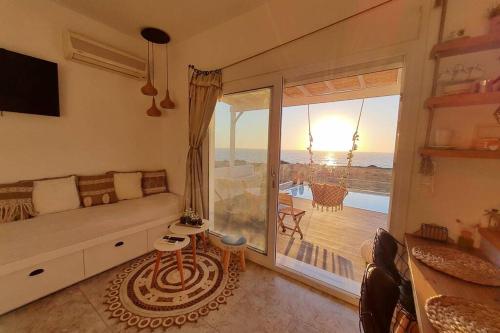a living room with a couch and a view of the ocean at Tramonto Luxury Villa No1- Breathtaking sunset view in Karpathos Town