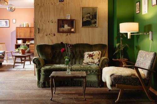 a living room with a green couch and a table at Hostel Ani&Haakien in Rotterdam