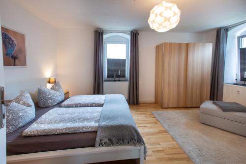 a bedroom with a bed and a couch and windows at FeWo 01 im Carré Charlott in Pulsnitz