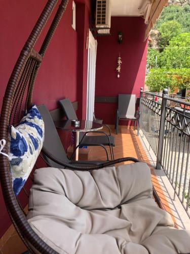 a porch with a hammock on a balcony at Elena Rista Studios in Parga
