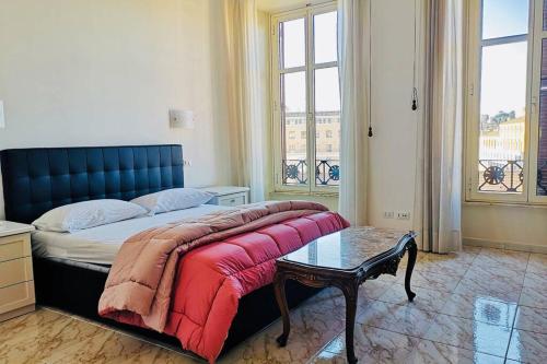 Schlafzimmer mit einem Bett mit einer roten Decke und einem Tisch in der Unterkunft St. Peter luxury home in Rom