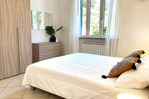 een slaapkamer met een groot wit bed en een raam bij Luminoso Bilocale con Balcone a Borgio Verezzi in Borgio Verezzi
