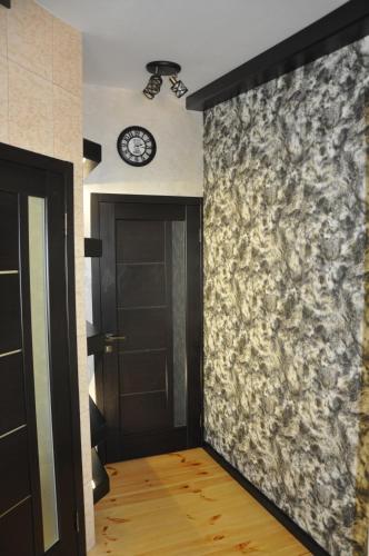 a hallway with a door and a clock on a wall at Дачний будинок in Kobelyaky
