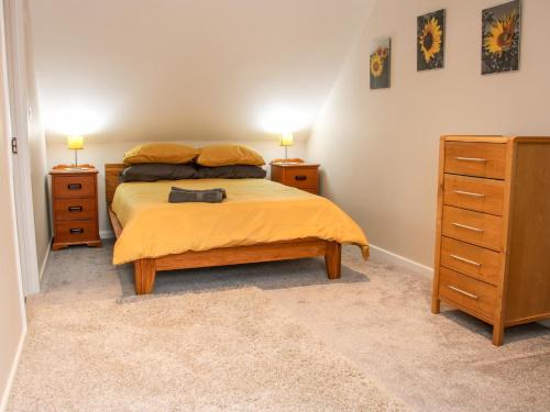 um quarto com uma cama e duas mesas de cabeceira e uma cómoda em Springfield House em Stafford
