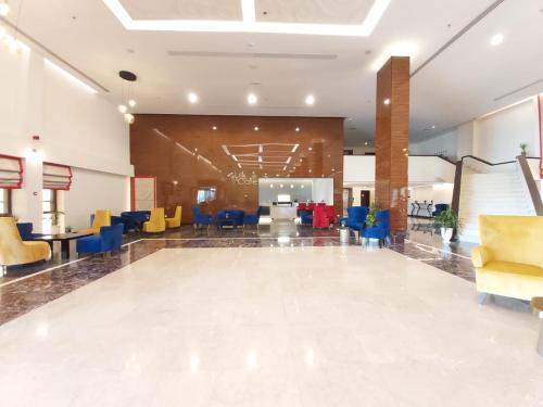 a lobby with a waiting area with colorful chairs at Basrah International Airport Hotel in Al Başrah