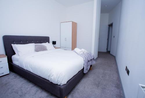 1 dormitorio con 1 cama grande con sábanas blancas en Spacious Urban City Apartment, en Doncaster