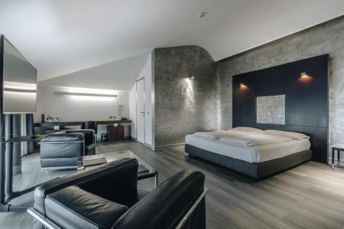 a bedroom with a bed and a living room at DelleArti Design Hotel in Cremona