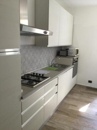 a kitchen with white cabinets and a stove top oven at 6alcentrale in Bellagio