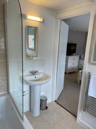 a white bathroom with a sink and a shower at Red Lion Inn in Sidbury