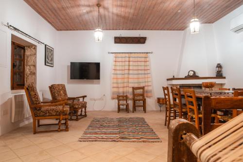 - un salon avec une table et des chaises dans l'établissement Droshia Traditional Homes, COCO-MAT Full Experience, à Droushia