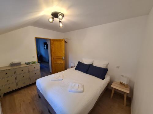 une chambre avec un grand lit blanc avec des oreillers bleus dans l'établissement Cottage Naomie, à Rue