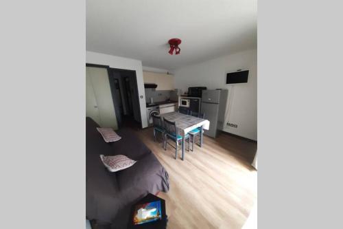 een woonkamer met een tafel en een keuken bij appartement T2 cabine en RDC avec terrasse in Saint-Lary-Soulan