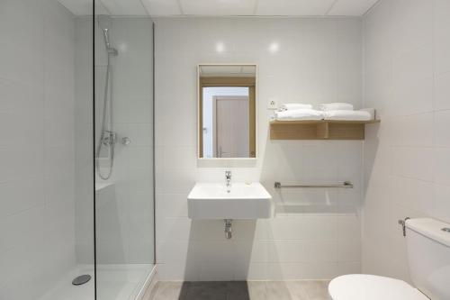 La salle de bains blanche est pourvue d'un lavabo et d'une douche. dans l'établissement SmartRoom Barcelona, à Barcelone