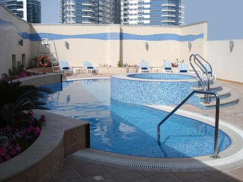 迪拜Belle Vue Building的一个带椅子和游泳池的大型游泳池