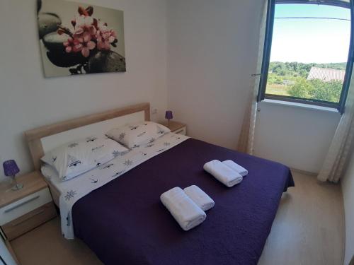 1 dormitorio con 1 cama con 2 toallas en Apartman Bukaleta in Loznati, en Loznati