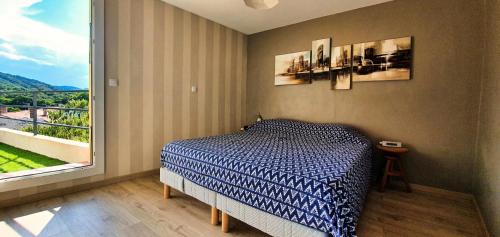 a bedroom with a bed and a large window at Le Micocoulier in Montesquieu