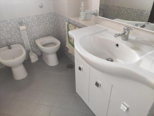 Baño blanco con lavabo y aseo en La quiete del Vesuvio en Nápoles