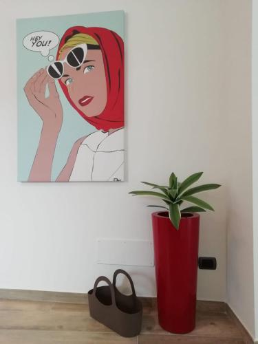 a painting of a woman with sunglasses and a potted plant at Nuvoleinviaggio in Sulmona