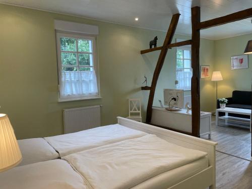 een slaapkamer met een groot wit bed en ramen bij Molehill Shire in Hückeswagen