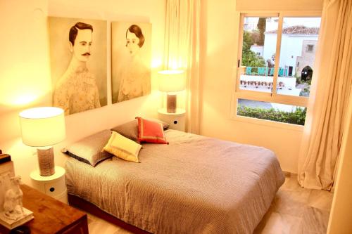 トレモリノスにあるInspiring Apartment in Carihuela Beachのベッドルーム1室(壁に2枚の写真が飾られたベッド1台付)