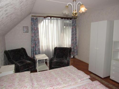 a bedroom with a bed and two chairs at Kossuth Apartman in Hajdúszoboszló