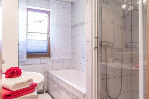 bagno bianco con doccia, vasca e lavandino di Apartment Salzburg City&Lake a Elixhausen