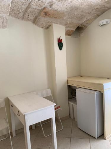 a kitchen with a white table and a table and a refrigerator at Amoredimare Casa Vacanze in Polignano a Mare