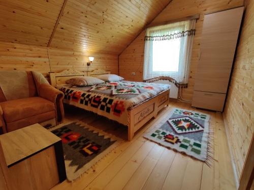 een slaapkamer met een bed in een blokhut bij Зелена садиба Валило in Kosiv