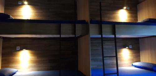 sypialnia z 2 łóżkami piętrowymi z oświetleniem w obiekcie ALBERGUE A QUEIMADA Exclusivo Peregrinos w mieście Caldas de Reis