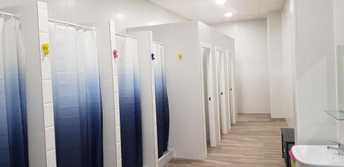 a row of stalls in a bathroom with a sink at albergue a queimada in Caldas de Reis