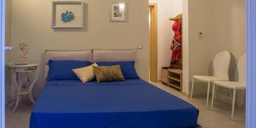 ジュルディニャーノにあるLe Tre Grazie B&Bのベッドルーム(青いベッド1台、椅子付)