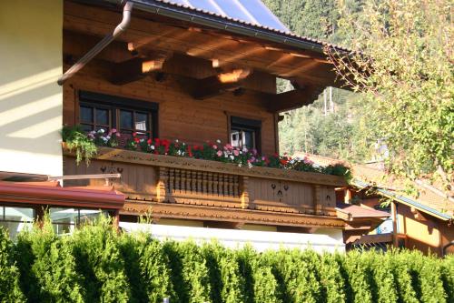 a house with a balcony with flowers on it at Ferienwohnung Prosch in Stumm