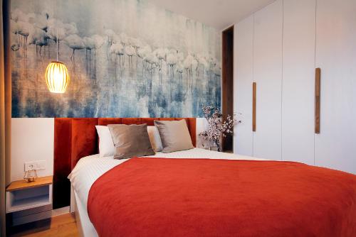 - une chambre avec un lit rouge orné d'une peinture murale dans l'établissement W&K Apartments - Harmony Suite, à Koszalin
