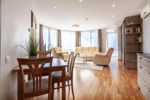 a kitchen and living room with a table and chairs at Elija Swan-Toy Apartments in Šventoji