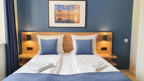 a bedroom with two beds with blue walls at Willa Abrazja - wypoczynek dla dorosłych in Jastrzębia Góra