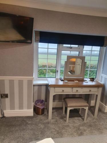 a desk with a mirror in a room with a window at The Croft Guest House in Narberth