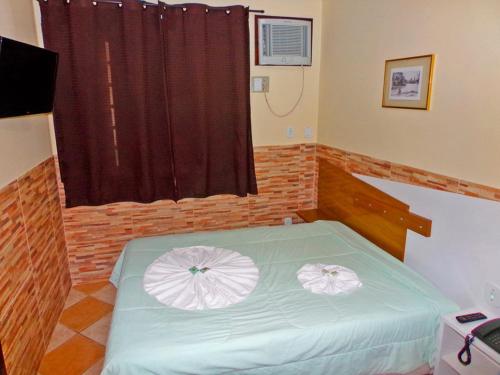 a bedroom with a bed with two white umbrellas on it at Hotel Colonial in Piraí