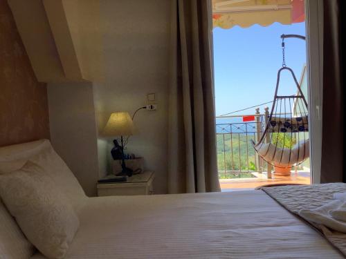 a bedroom with a bed and a window with a balcony at Elena Rista Studios in Parga