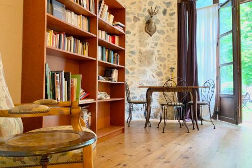 a room with a table and chairs and a book shelf at The Uriage Castle #BV in Saint-Martin-dʼUriage