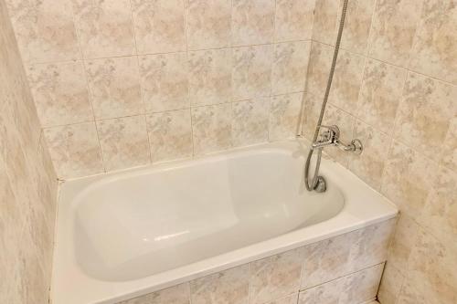 a white bath tub in a tiled bathroom at #BV Le Château d'Uriage in Saint-Martin-dʼUriage