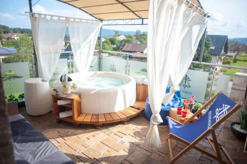 a hot tub sitting on a patio with a view at Hotel Tommy Wellness & Spa in Náchod