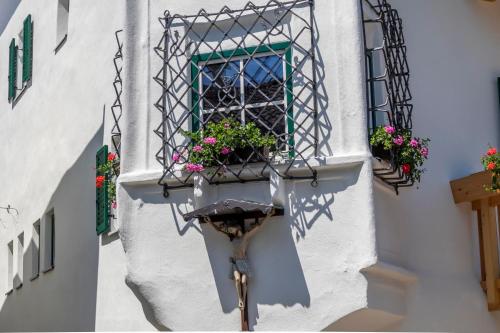 a window with a flower pot on a building at Engel Appartements Kirchturm in Parcines