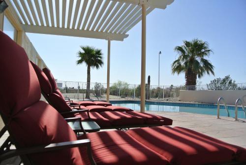 a row of chairs sitting next to a swimming pool at Borrego Springs Motel in Borrego Springs