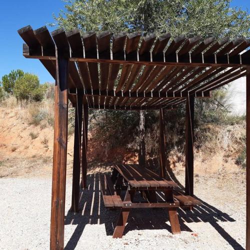 a wooden shelter with a picnic table under it at Blesamemucho - Casa Rural Situada en BLESA 