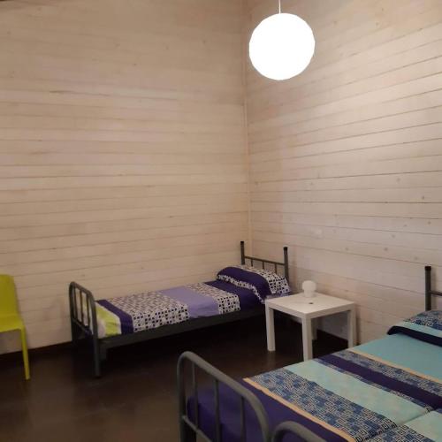 Cette chambre comprend deux lits, une table et une lampe. dans l'établissement Blesamemucho - Casa Rural Situada en BLESA, 