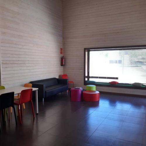 sala de estar con sofá, mesas y ventana en Blesamemucho - Casa Rural Situada en BLESA, 